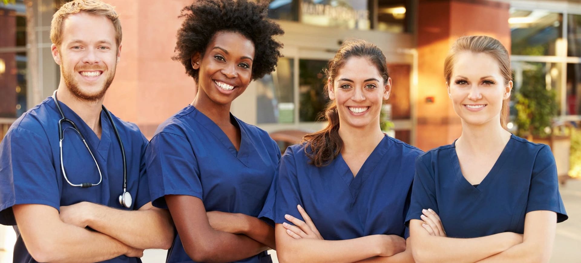 Two nurses standing next to each other smiling.