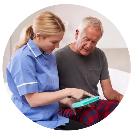 A nurse and an older man looking at something on a tablet.